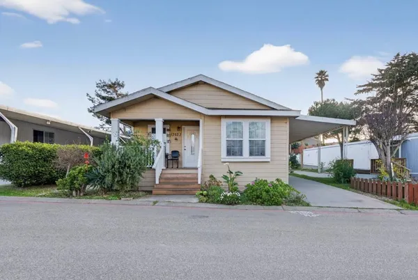 a front view of a house with a yard and outdoor seating