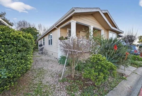 a front view of a house with plants