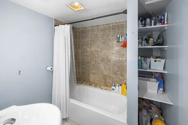 a bathroom with a bathtub a toilet and a shower