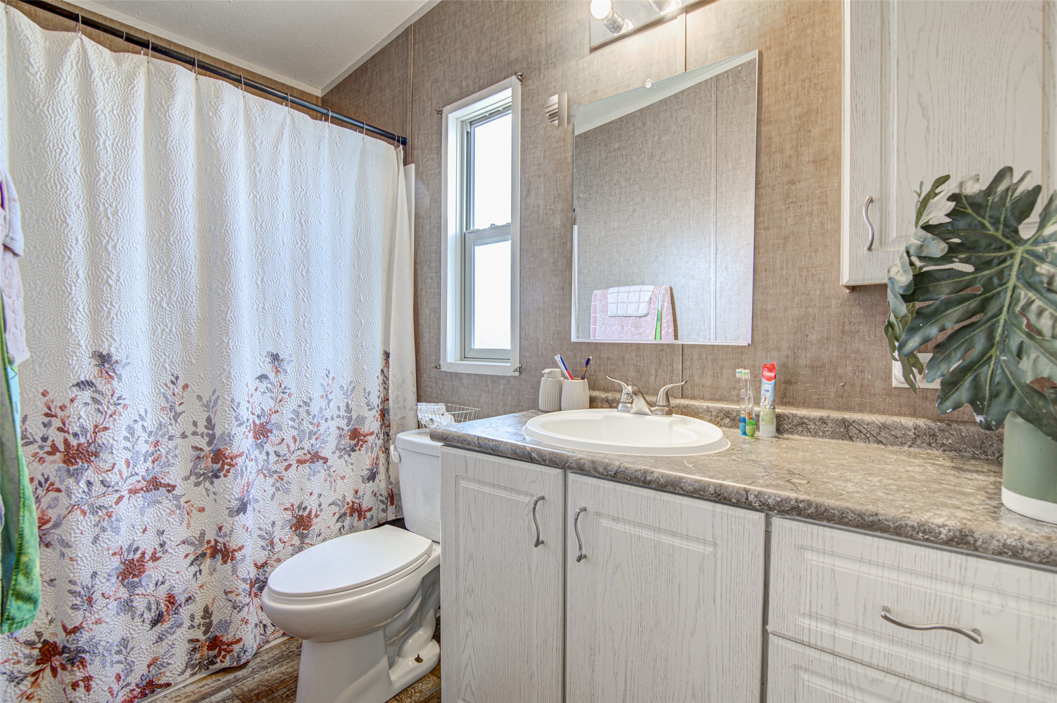 445 Rancho Linda Drive Lockhart, TX 78644 - Photo 24 of 26 A well-lit bathroom with a vanity and a shower-tub combination.