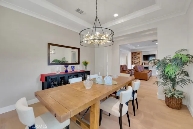 a view of a dining room with furniture a chandelier and wooden floor