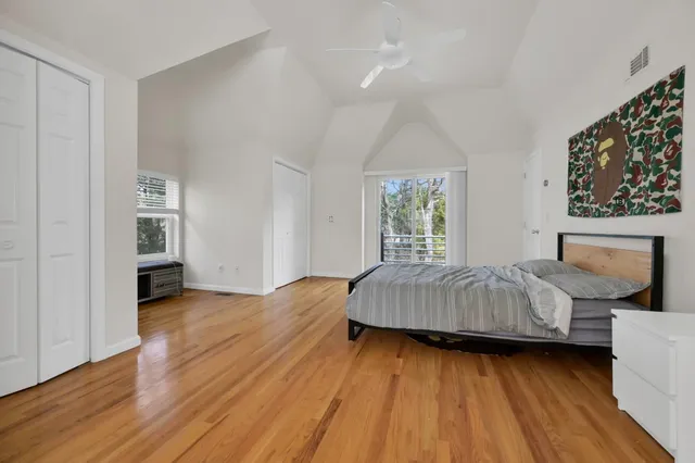 a bedroom with a bed and wooden floor