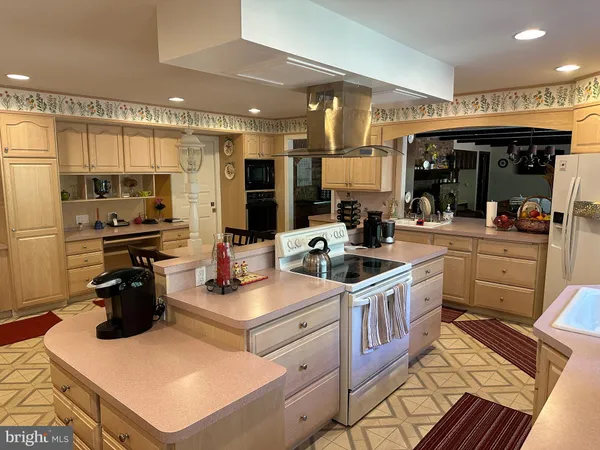 a kitchen with a sink a stove and chairs