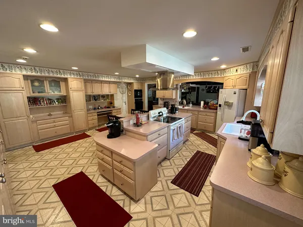 a kitchen filled with stainless steel appliances kitchen island granite countertop a sink and a refrigerator
