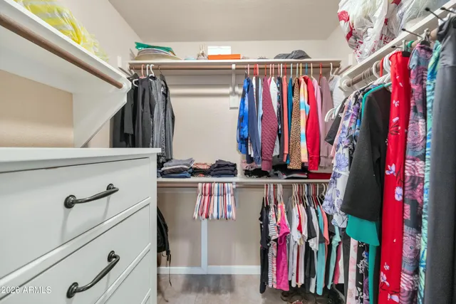 a view of walk in closet with clothes