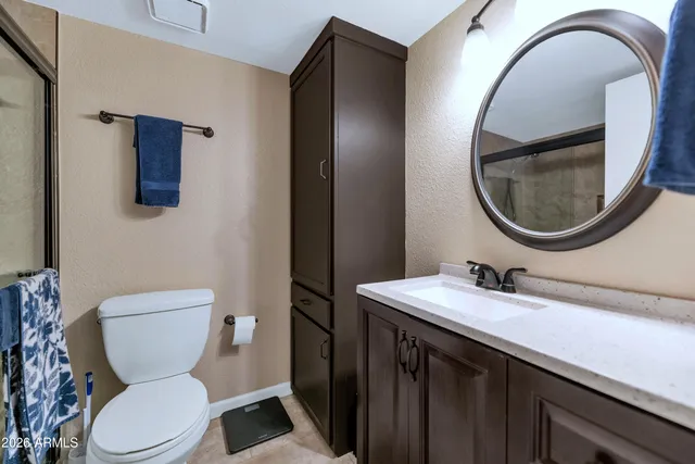 a bathroom with a toilet a sink and a mirror