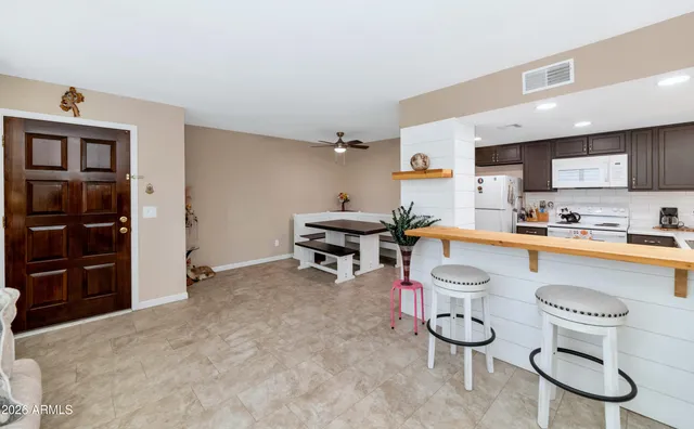 a living room with furniture a refrigerator and cabinets