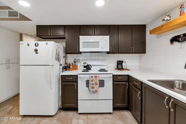 a kitchen with stainless steel appliances granite countertop a refrigerator a stove a sink and a microwave