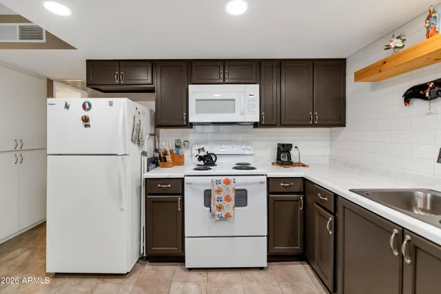 a kitchen with stainless steel appliances granite countertop a refrigerator a stove a sink and a microwave