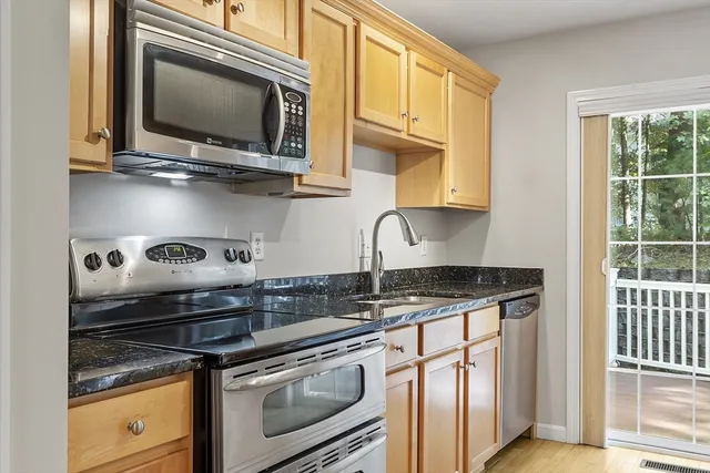a kitchen with stainless steel appliances granite countertop a stove and a microwave