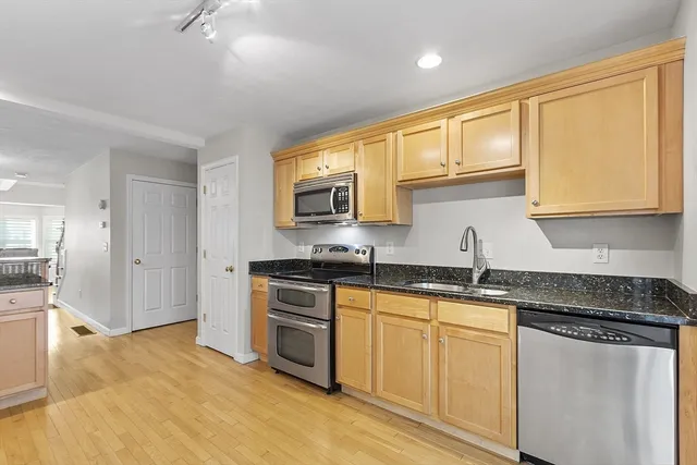 a kitchen with granite countertop cabinets stainless steel appliances a sink and a counter top space