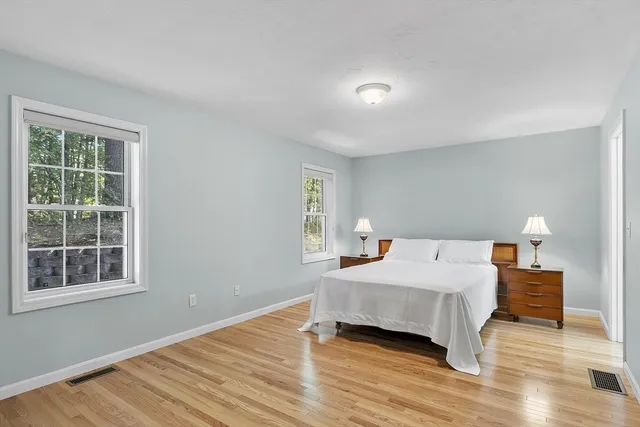 a bedroom with a bed and wooden floor
