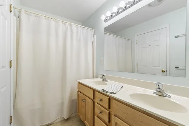 a bathroom with a double vanity sink and a mirror