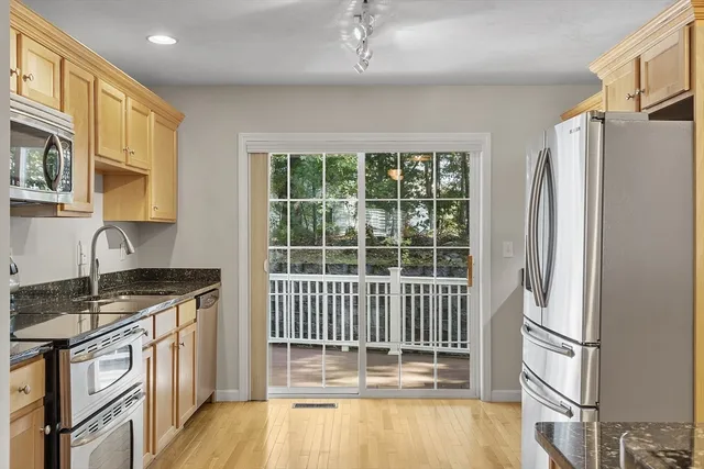 a kitchen with stainless steel appliances granite countertop a stove a refrigerator and a cabinets