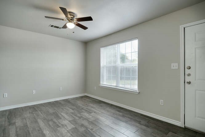 107 Castleberry Court, Unit D Bertram, TX 78605 - Photo 4 of 13 Spare room featuring dark wood-type flooring and ceiling fan