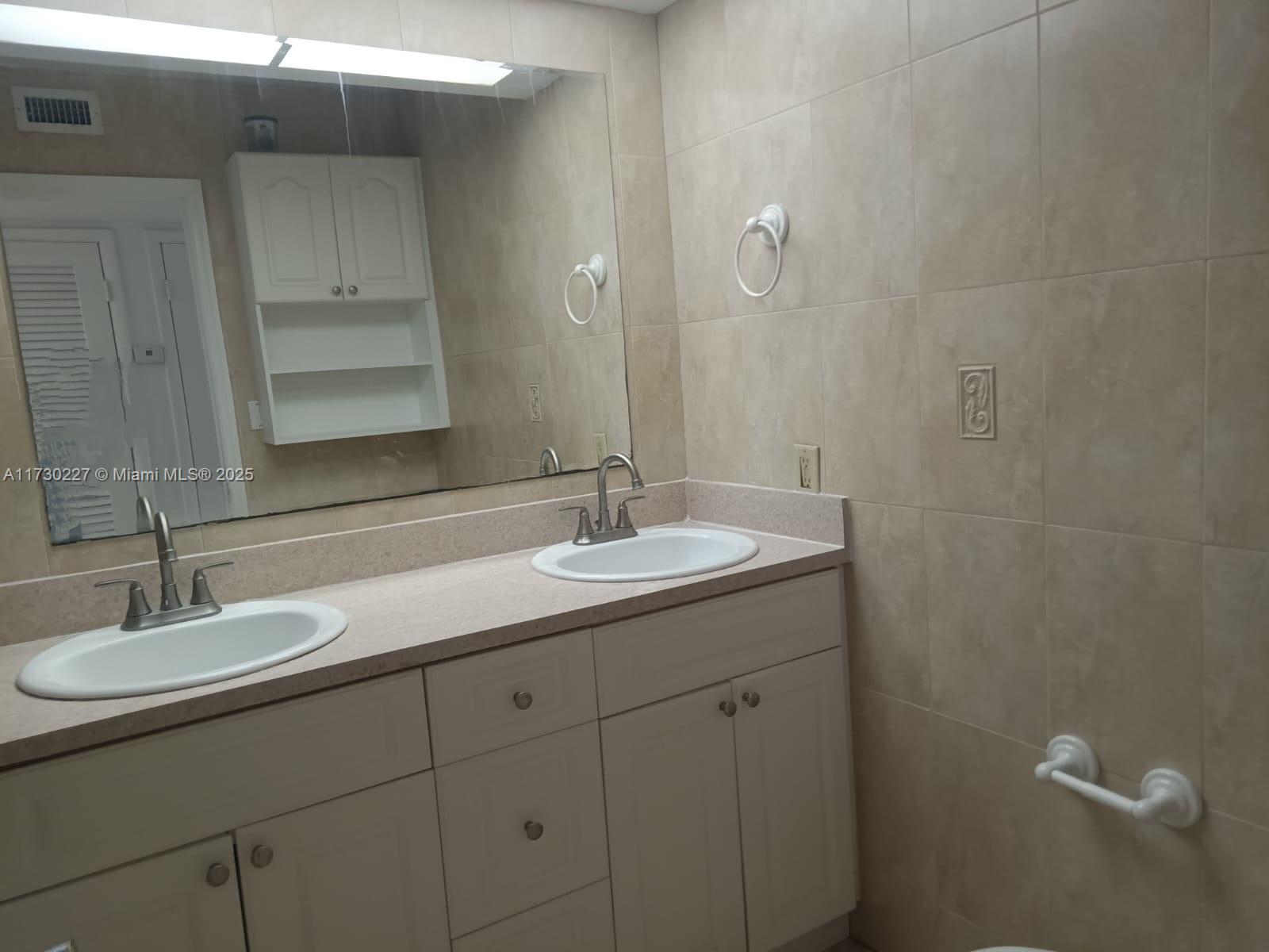 7348 Southwest 82nd Street, Unit C217 Miami, FL 33143 - Photo 10 of 19 a bathroom with a sink and a mirror