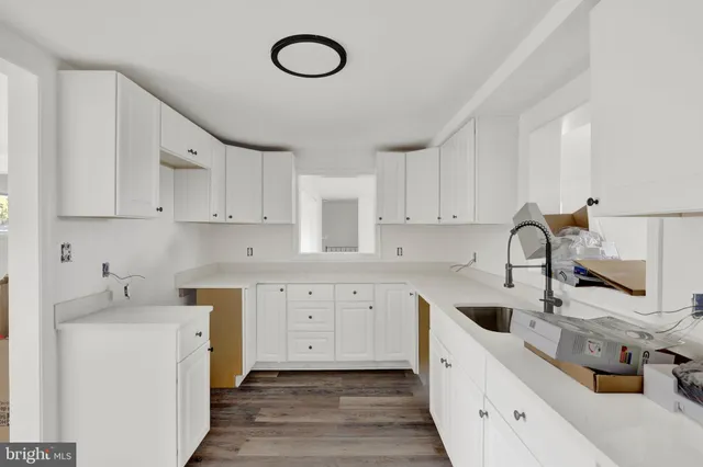 a kitchen with cabinets a sink and white appliances