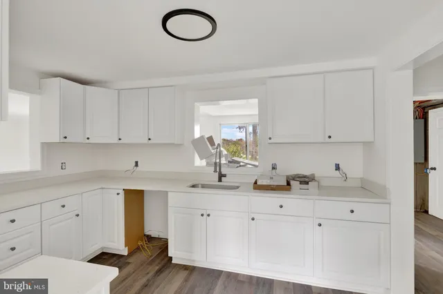 a kitchen with white cabinets appliances and sink