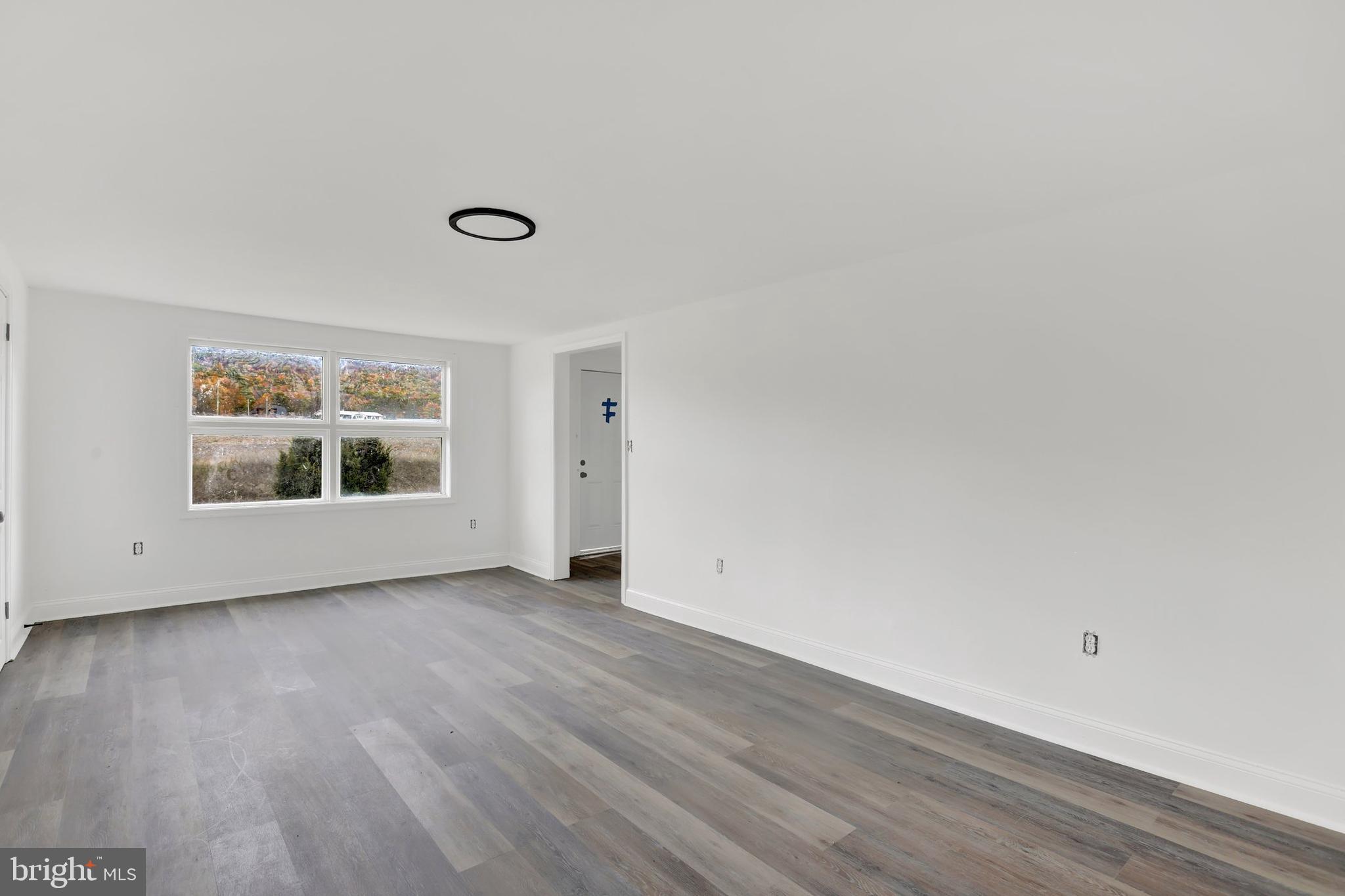 664 South Breezewood Road Breezewood, PA 15533 - Photo 6 of 24 a view of an empty room with wooden floor and a window