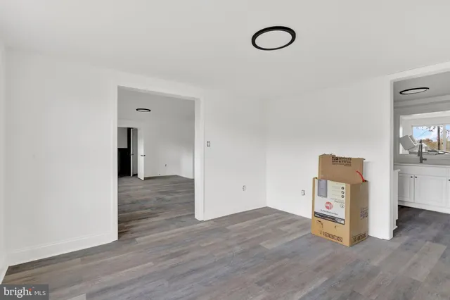 an empty room with wooden floor and mirror