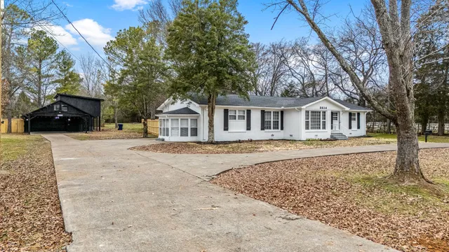 a view of a house with a backyard and a tree