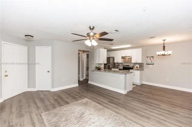a kitchen with a refrigerator and white cabinets