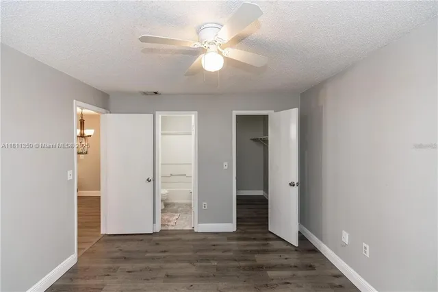 an empty room with wooden floor and ceiling fan