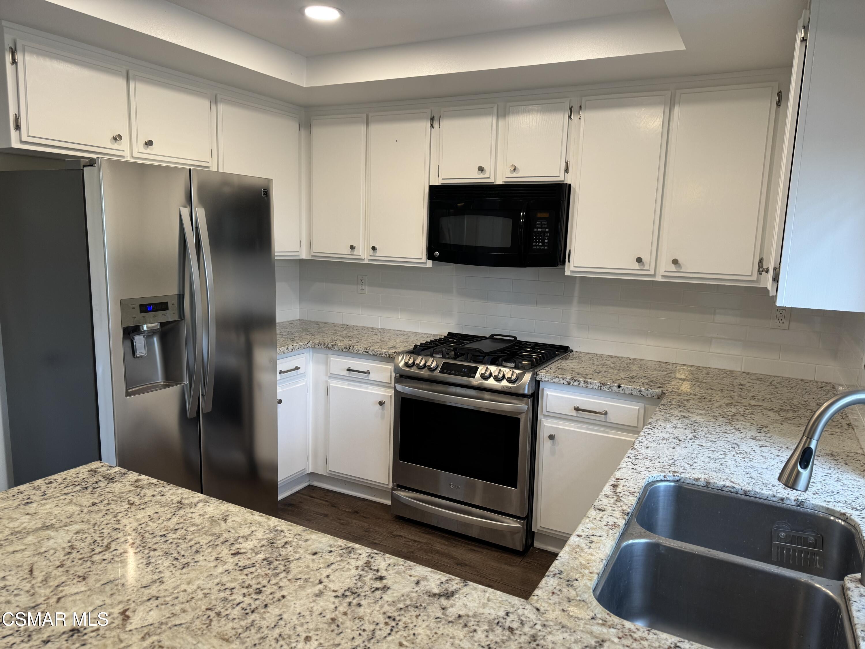 26914 Deerweed Trail Calabasas, CA 91301 - Photo 13 of 37 a kitchen with stainless steel appliances granite countertop a stove a refrigerator and a sink with wooden cabinets