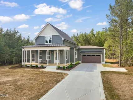 a front view of a house with a yard and trees