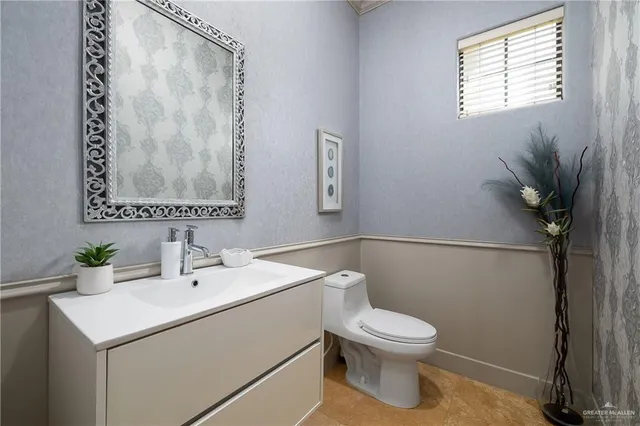 a bathroom with a toilet sink and mirror