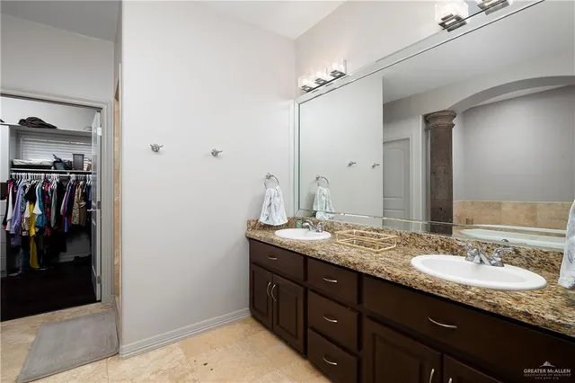 a bathroom with a granite countertop sink double and mirror
