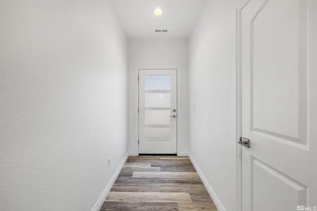 a view of a hallway with wooden floor and entryway