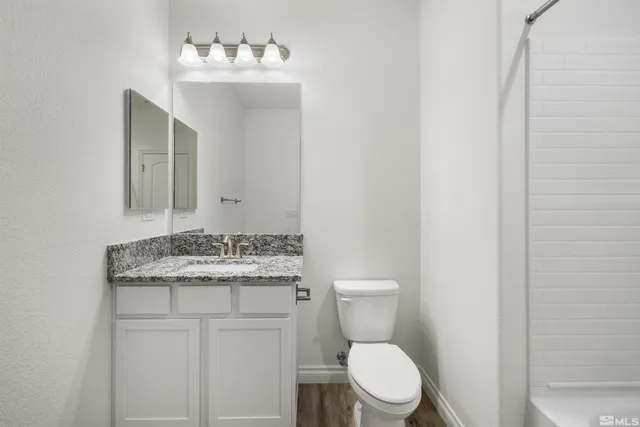 a bathroom with a sink vanity mirror and toilet