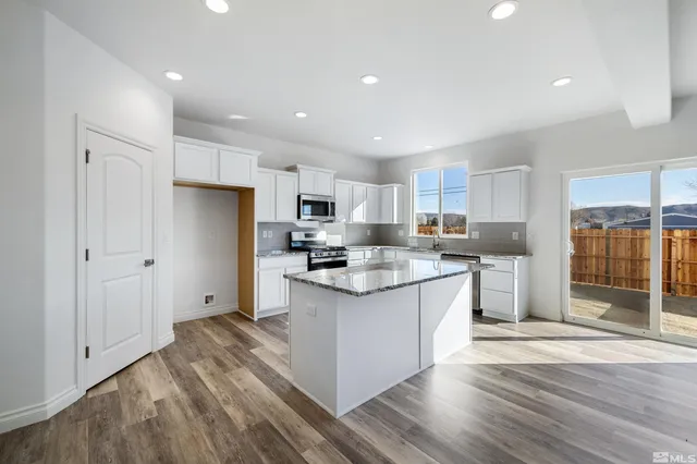 a kitchen with stainless steel appliances granite countertop a refrigerator and a stove top oven