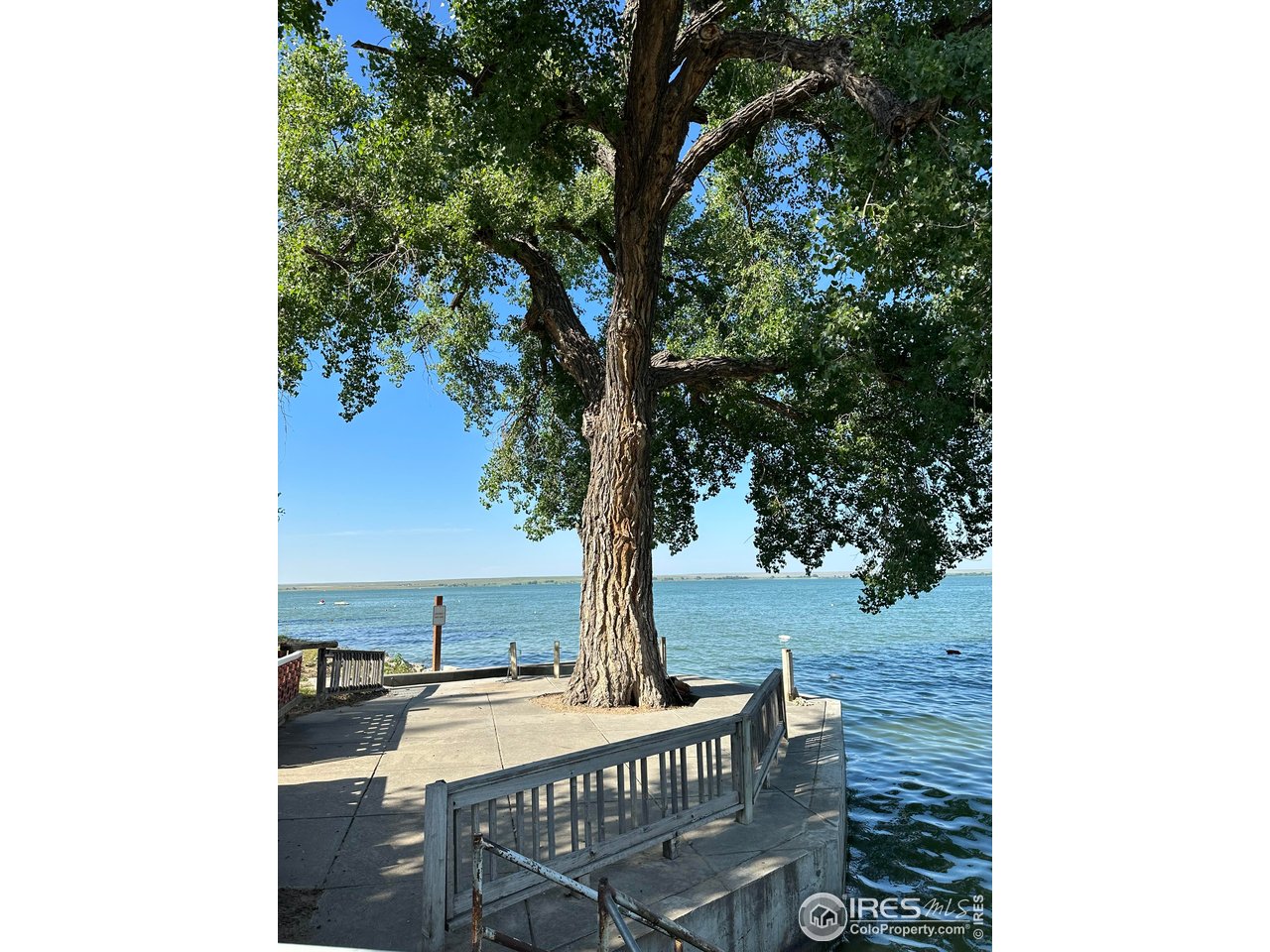 213 Kiowa Road Weldona, CO 80653 - Photo 19 of 25 a view of a terrace with a table and chairs under an umbrella
