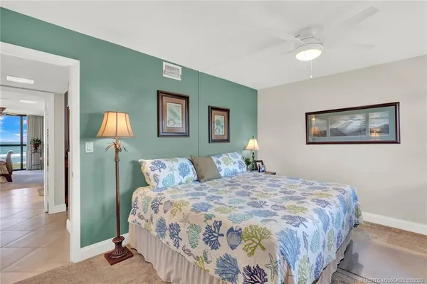 a bedroom with a bed and painting on the wall