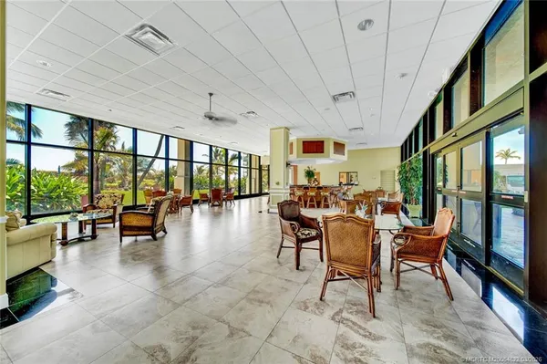 a room with lots of glass windows table and chairs