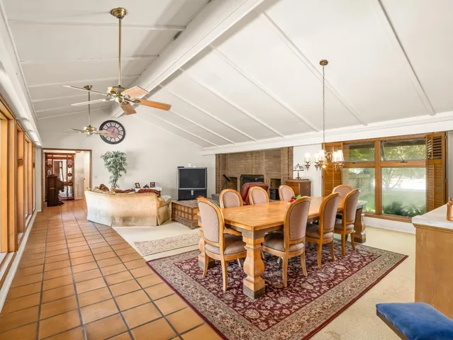 a kitchen with stainless steel appliances granite countertop a sink a stove a dining table and chairs