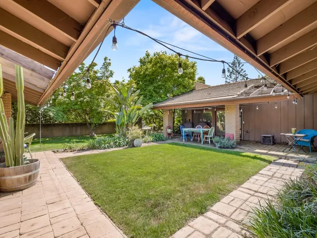 a view of a house with backyard and sitting area
