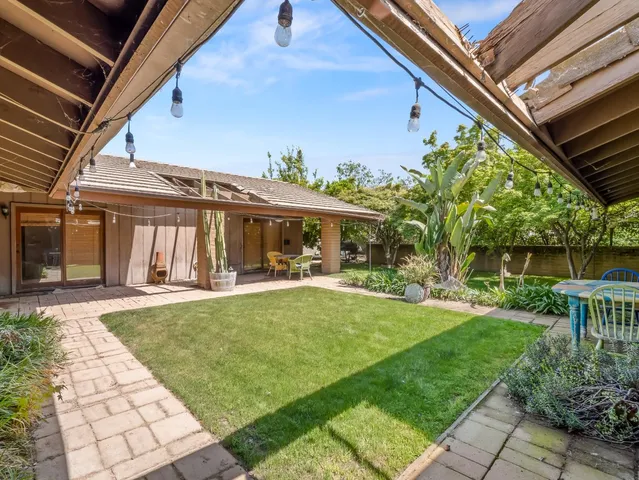 a view of a house with backyard and sitting area