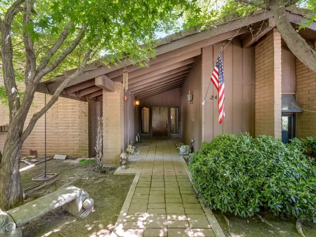 a view of a pathway door with tree in front of it