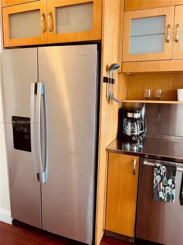 a kitchen with stainless steel appliances granite countertop a sink and a refrigerator