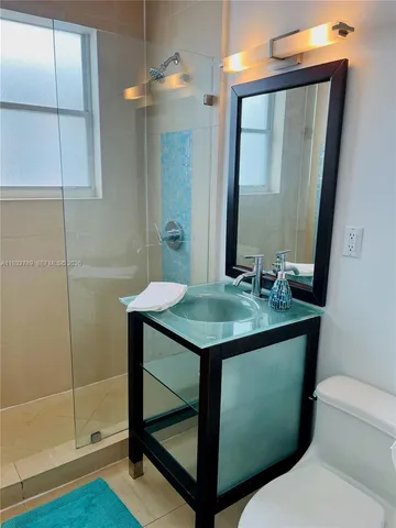a bathroom with a sink toilet and mirror