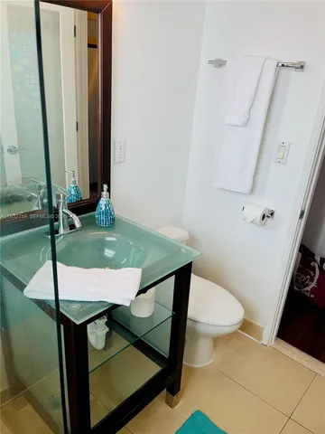 a bathroom with a granite countertop sink a toilet and a mirror