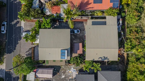 an aerial view of a house with a yard and a tree