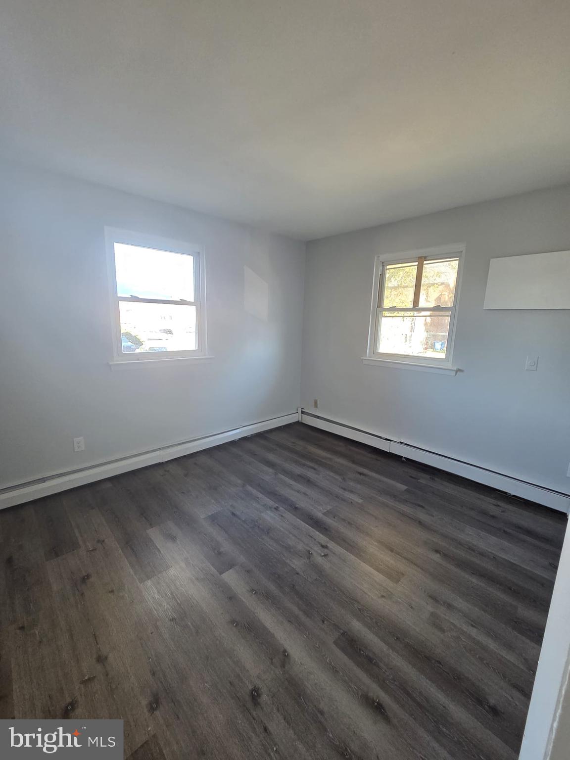 18 West 22nd Street, Unit A15 Chester, PA 19013 - Photo 2 of 6 an empty room with wooden floor and windows