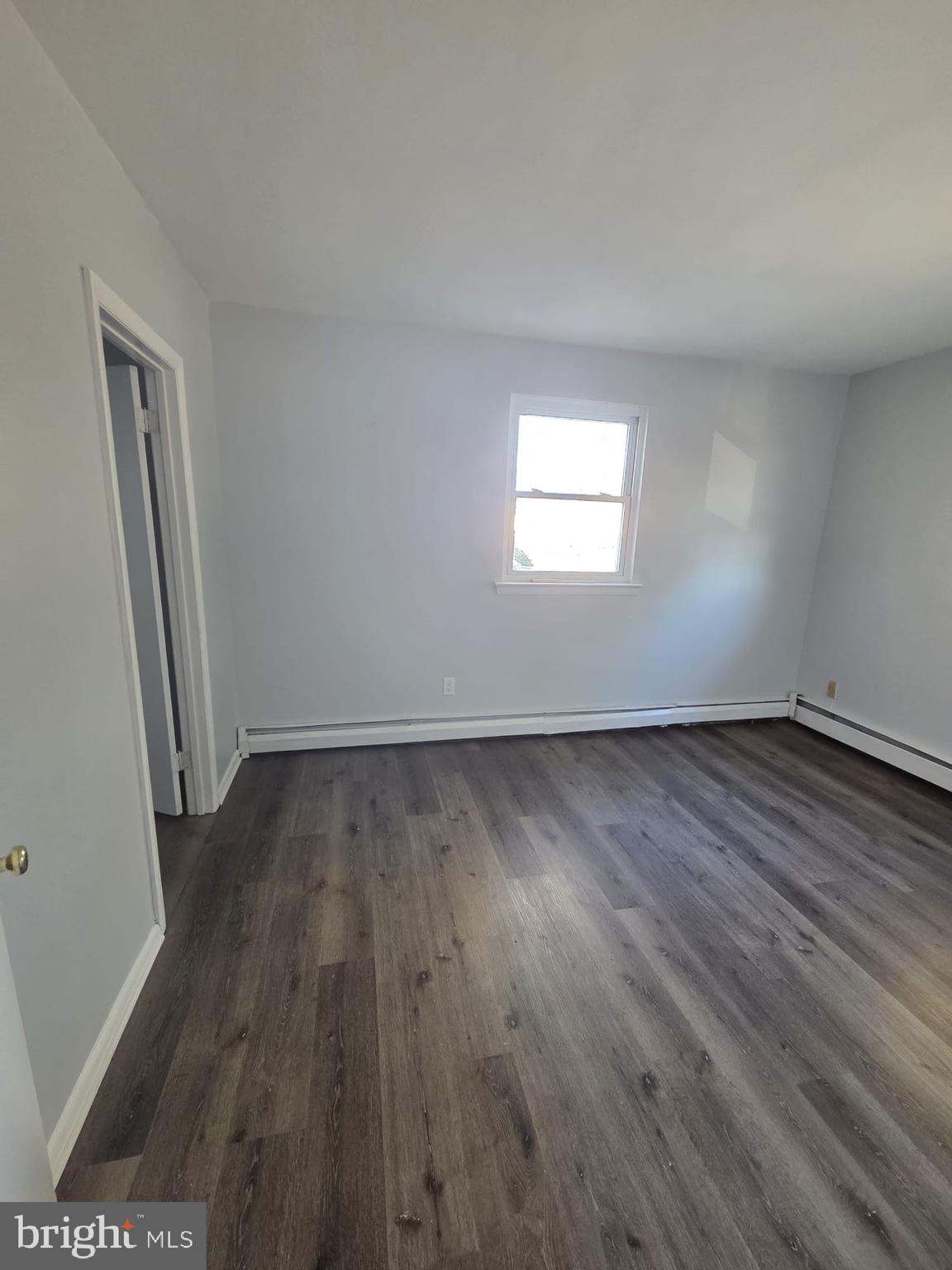 18 West 22nd Street, Unit A15 Chester, PA 19013 - Photo 3 of 6 an empty room with wooden floor and windows