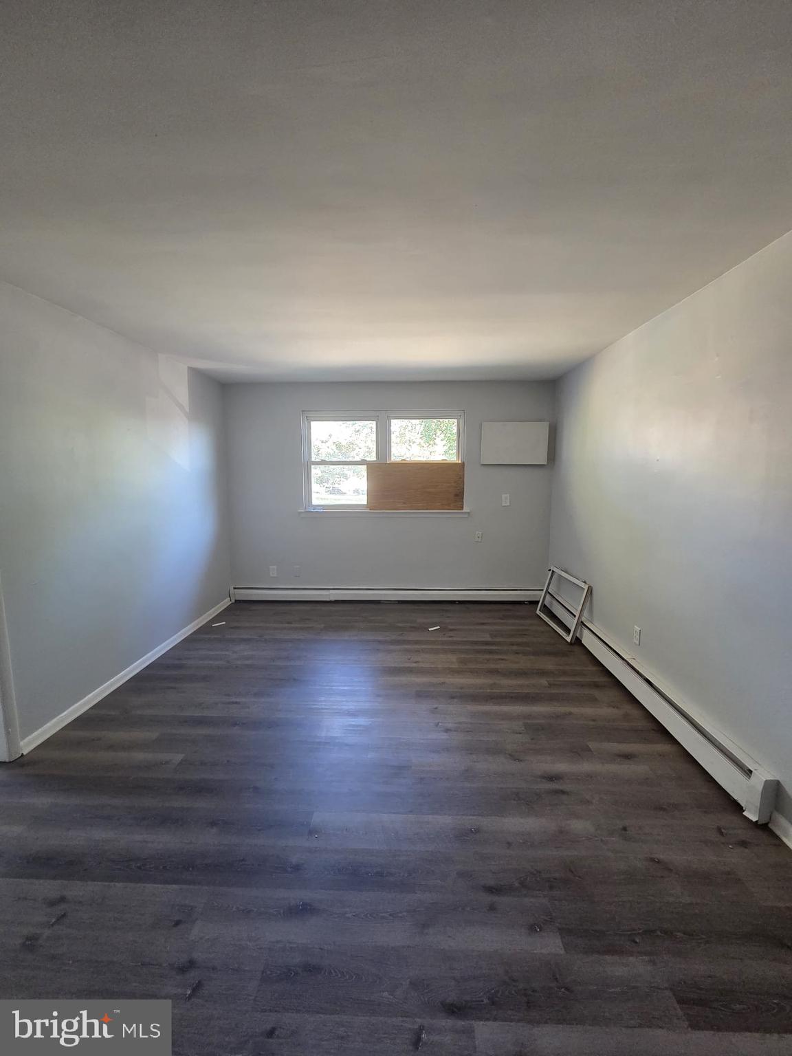 18 West 22nd Street, Unit A15 Chester, PA 19013 - Photo 4 of 6 an empty room with wooden floor and windows