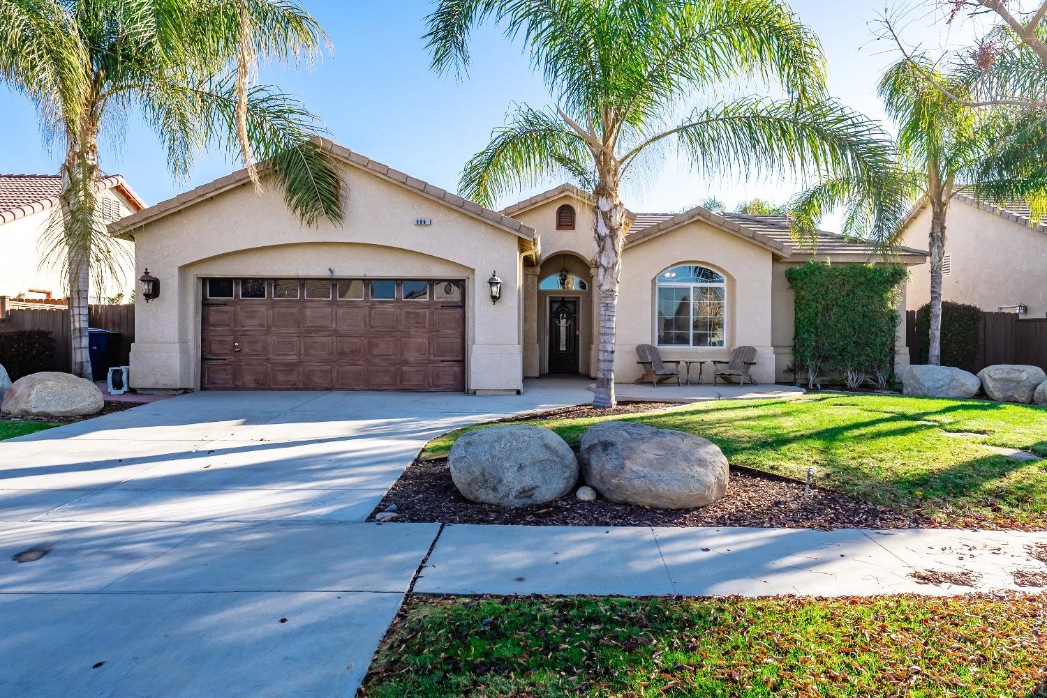 a front view of a house with garden and swimming pool