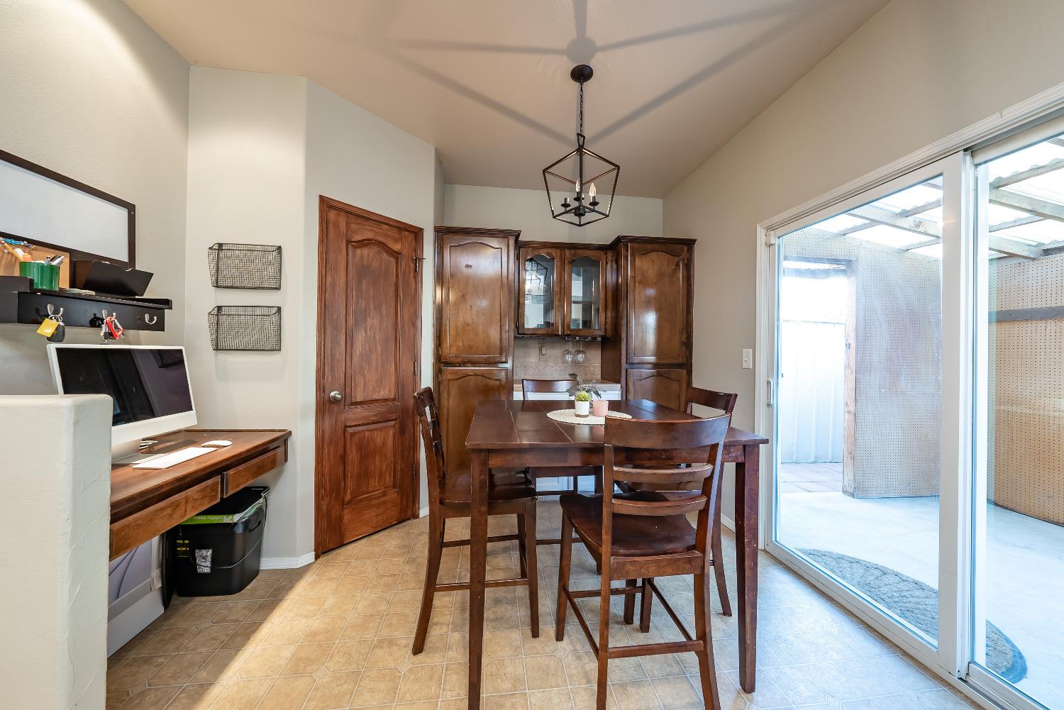 696 Crescent Lane Lemoore, CA 93245 - Photo 14 of 35 a view of a dining room with furniture a chandelier and wooden floor